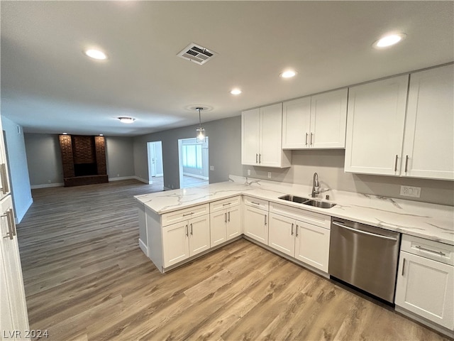 kitchen with kitchen peninsula, light hardwood / wood-style flooring, dishwasher, a fireplace, and sink