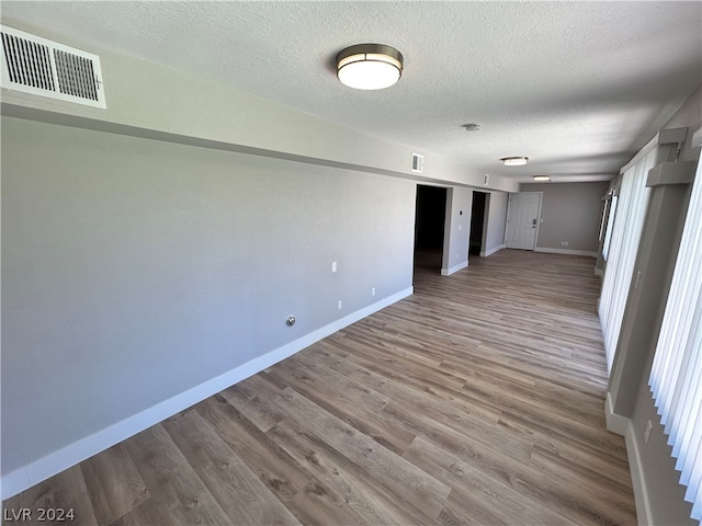 empty room with hardwood / wood-style flooring and a textured ceiling