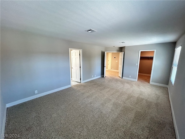 unfurnished room with light carpet and a textured ceiling