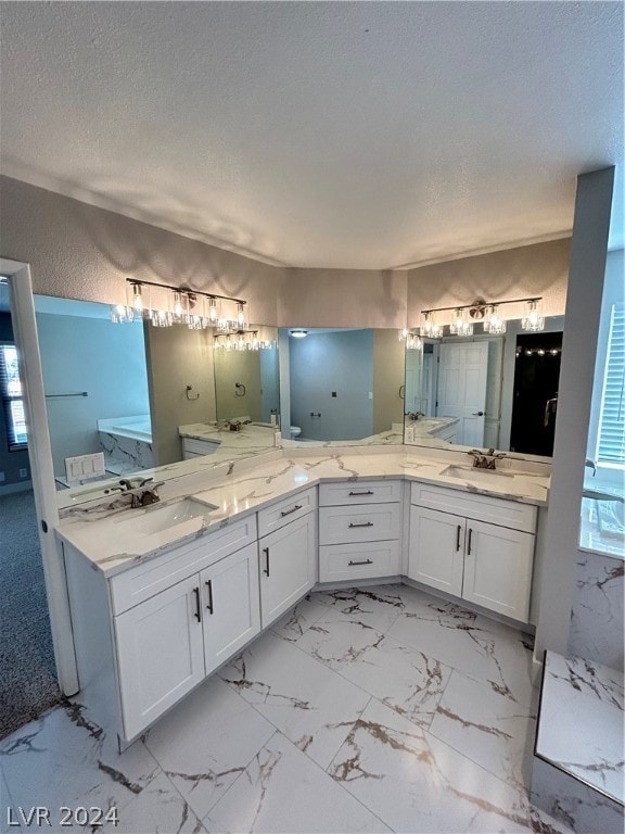 bathroom featuring a textured ceiling, dual vanity, and tile flooring