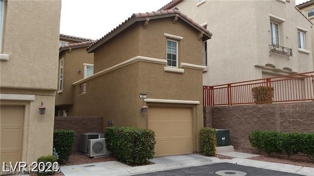 view of front of home featuring central AC unit and a garage