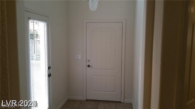 doorway to outside with light tile flooring