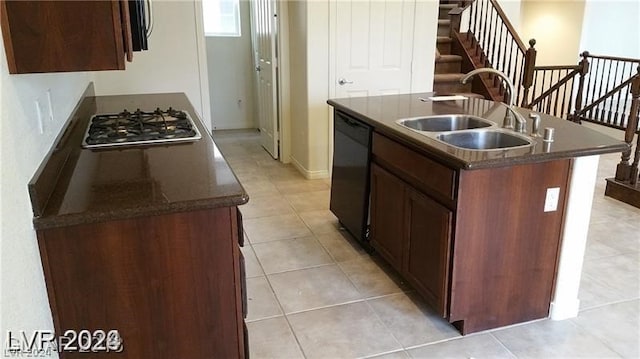 kitchen featuring stainless steel gas stovetop, a center island with sink, light tile floors, and sink