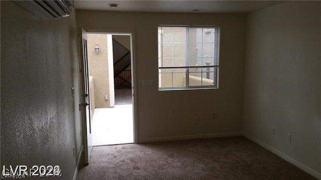 carpeted spare room featuring a wall mounted air conditioner