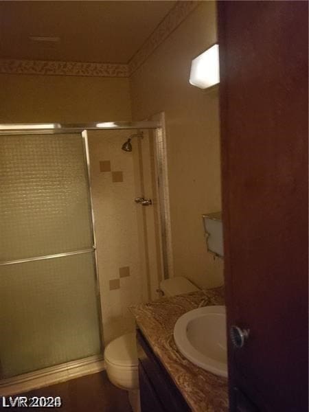 bathroom with a shower with shower door, vanity, and toilet