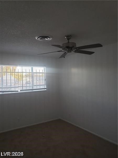 carpeted empty room with plenty of natural light, ceiling fan, and a textured ceiling