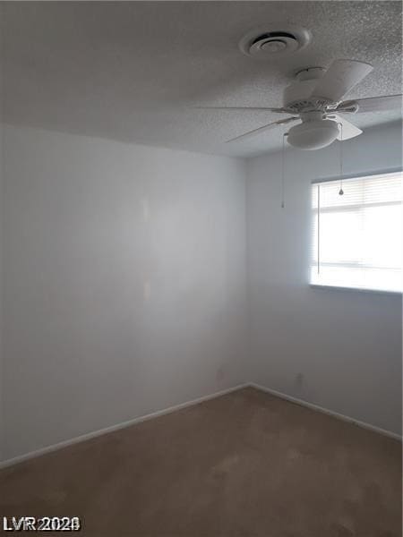 spare room with ceiling fan, carpet, and a textured ceiling