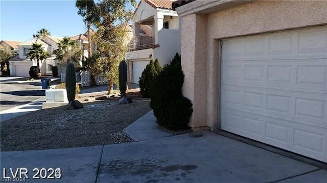 view of side of property featuring a balcony and a garage