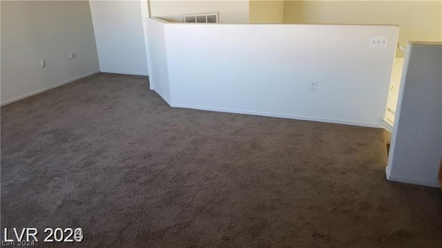 spare room with dark colored carpet