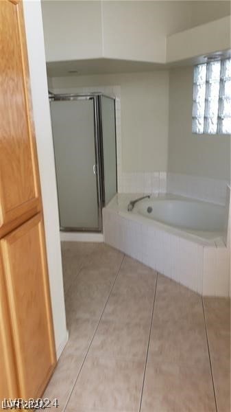 bathroom featuring tile floors and independent shower and bath