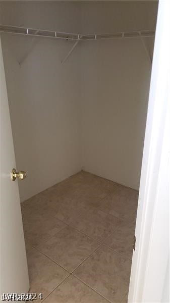 walk in closet featuring light tile flooring