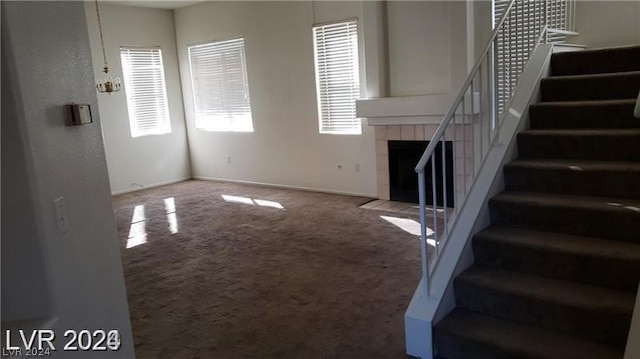 unfurnished living room with light colored carpet and a fireplace