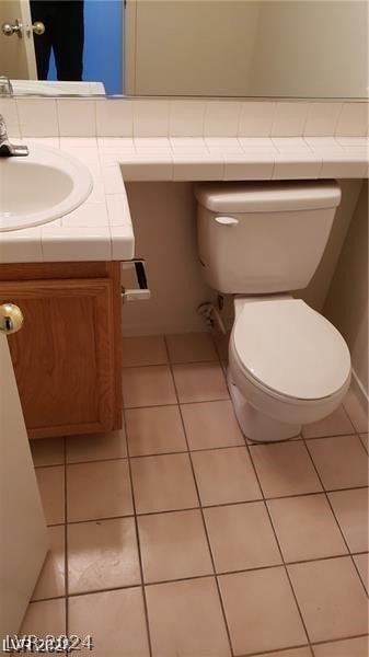 bathroom featuring tile flooring, toilet, and vanity