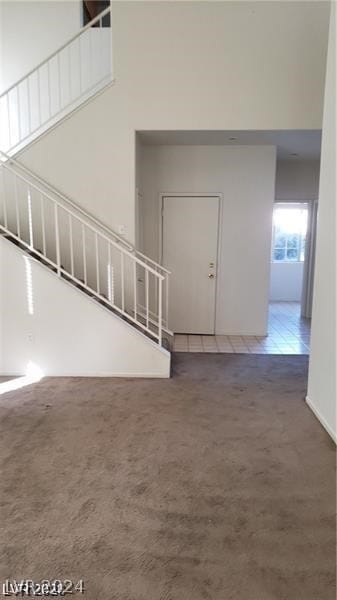 interior space with a high ceiling and dark colored carpet