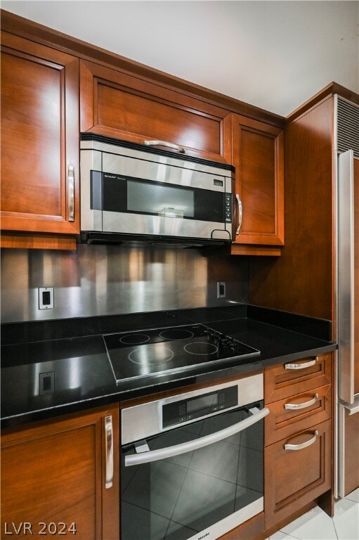 kitchen featuring light tile flooring and stainless steel appliances