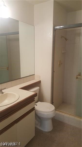 bathroom featuring toilet, vanity, an enclosed shower, and tile floors