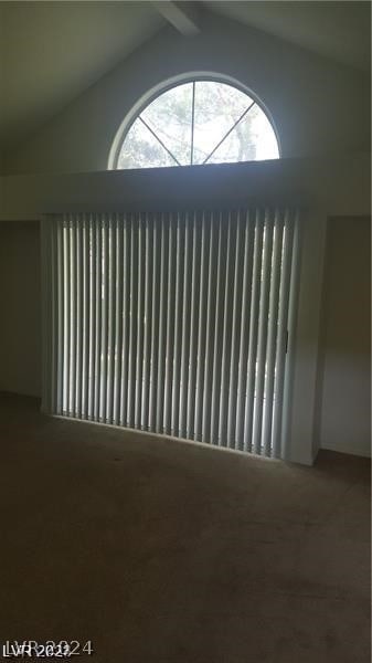 carpeted empty room featuring lofted ceiling