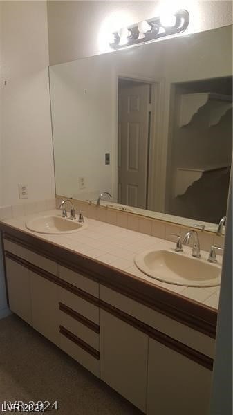 bathroom featuring dual sinks and vanity with extensive cabinet space