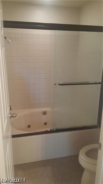 bathroom with bath / shower combo with glass door and toilet