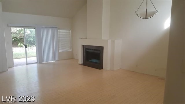 unfurnished living room with lofted ceiling and light wood-type flooring