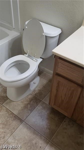 bathroom with tile flooring, toilet, and vanity