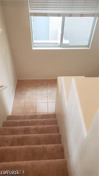 stairway featuring light tile floors