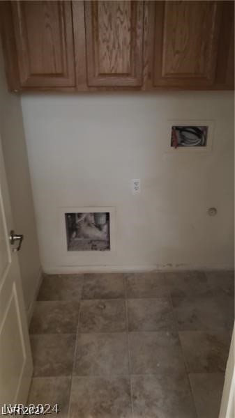 laundry area with cabinets and tile floors