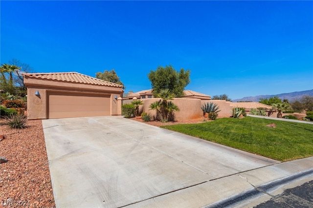 view of front of house with a mountain view, a garage, and a front yard