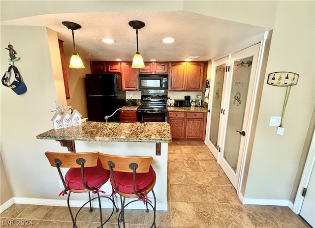 kitchen featuring light tile floors, black appliances, light stone countertops, and hanging light fixtures