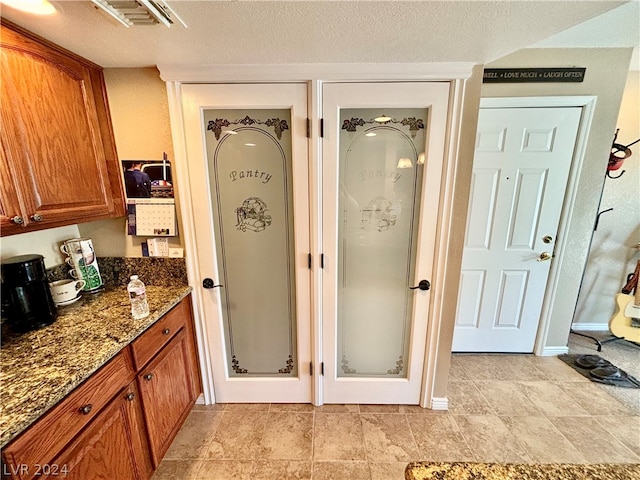 bathroom featuring a textured ceiling, vanity, tile floors, and walk in shower