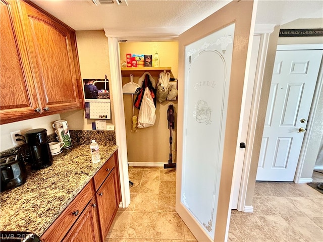 interior space with light stone countertops and light tile flooring