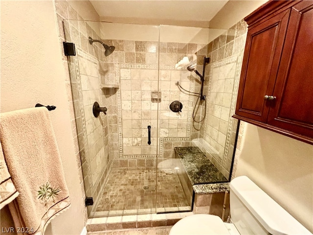 bathroom featuring toilet and a shower with door