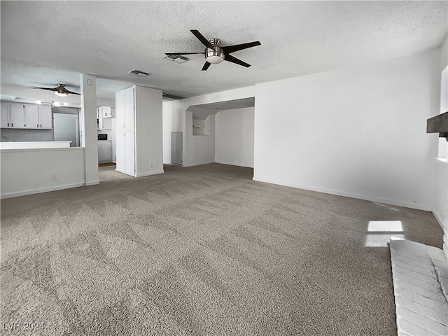 unfurnished living room featuring ceiling fan, light colored carpet, and a textured ceiling