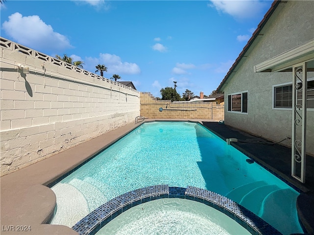 view of pool with an in ground hot tub