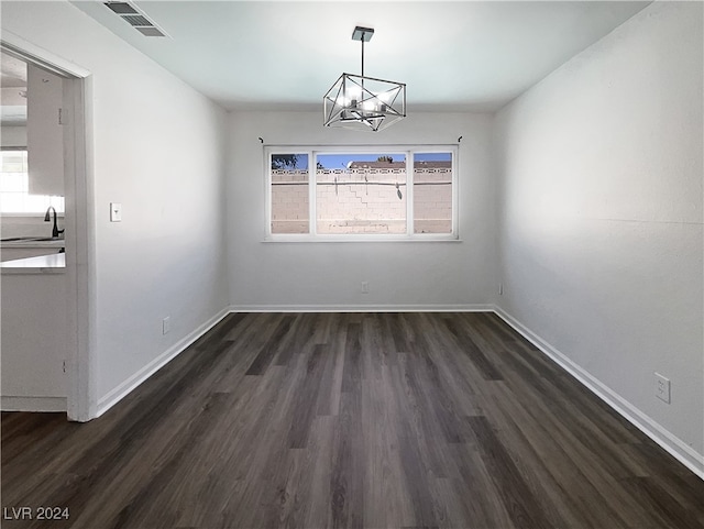 empty room featuring sink, an inviting chandelier, and dark hardwood / wood-style flooring