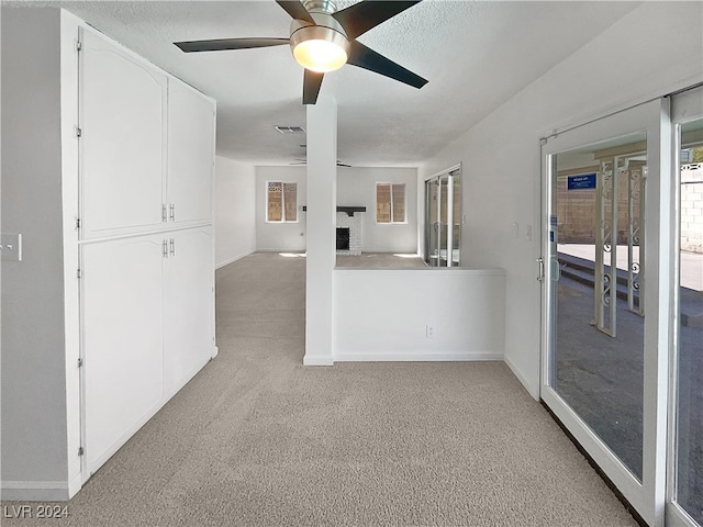 unfurnished room featuring ceiling fan, a wealth of natural light, and light colored carpet