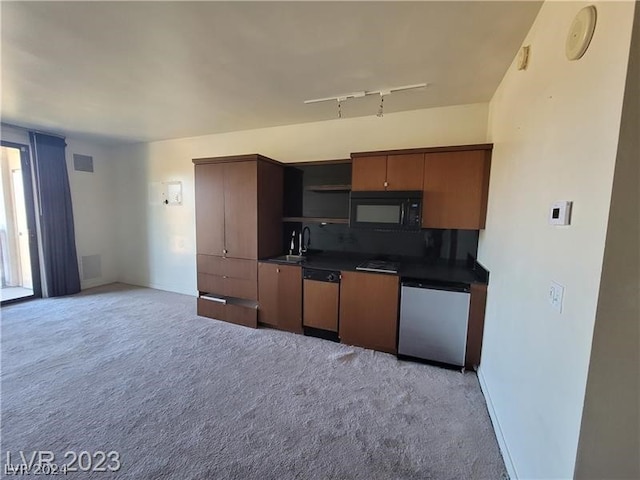 kitchen with rail lighting, light carpet, dishwasher, and sink