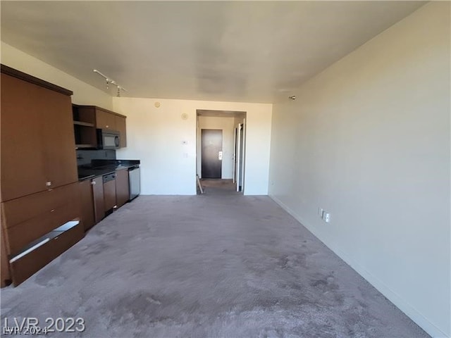 unfurnished living room with rail lighting and carpet