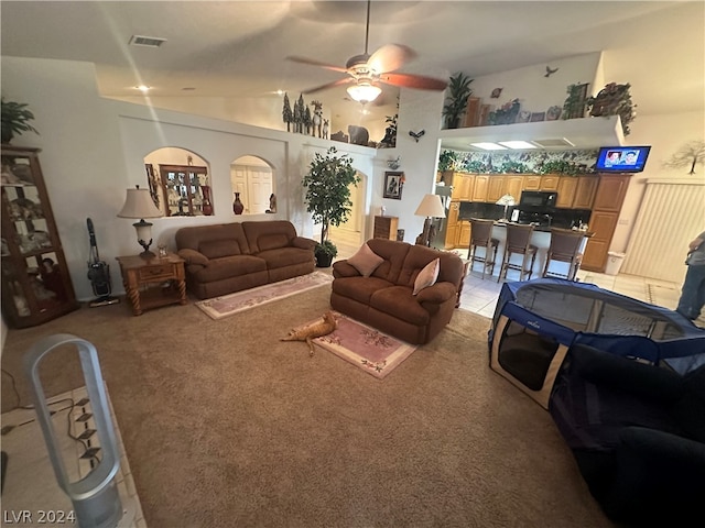 living room featuring high vaulted ceiling, ceiling fan, and light colored carpet