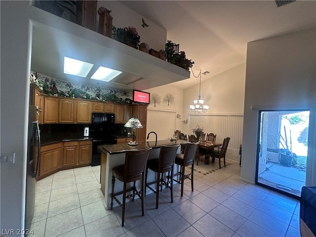 kitchen with black appliances, light tile floors, and an inviting chandelier