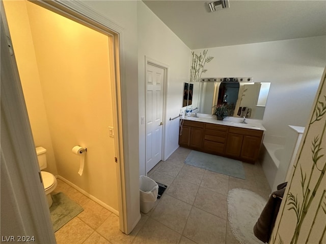 bathroom featuring double vanity, toilet, and tile floors