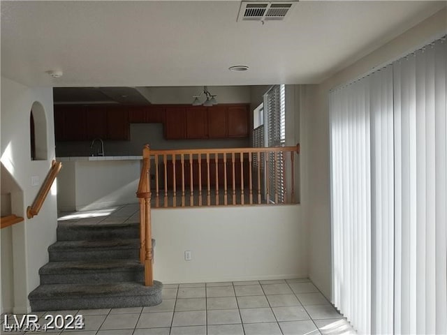 stairs featuring sink and light tile floors