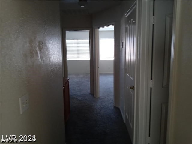 corridor with dark colored carpet