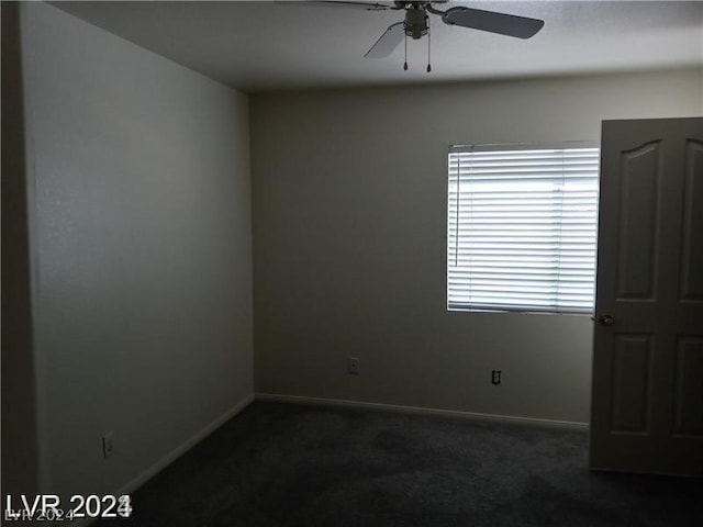 spare room with dark carpet and ceiling fan