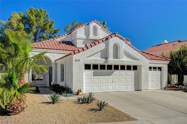 mediterranean / spanish home with a garage