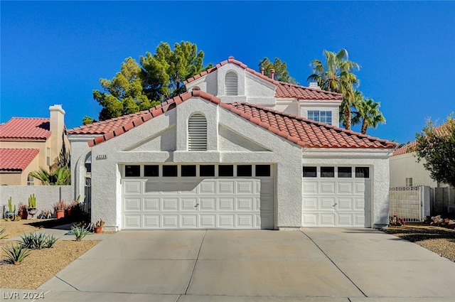 mediterranean / spanish home with a garage