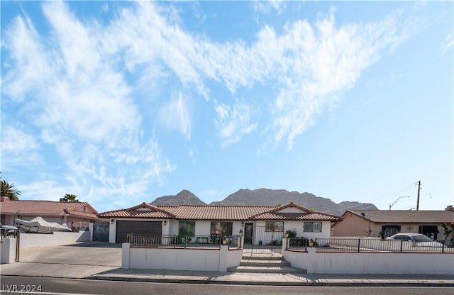 view of front of home featuring a garage, stucco siding, a tiled roof, a fenced front yard, and driveway
