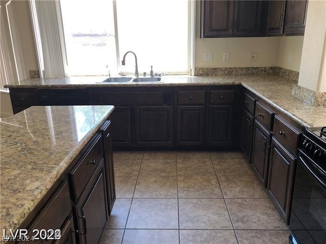 kitchen with sink, light stone countertops, and light tile flooring