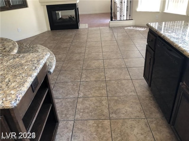 interior space featuring a multi sided fireplace, black dishwasher, and light tile floors