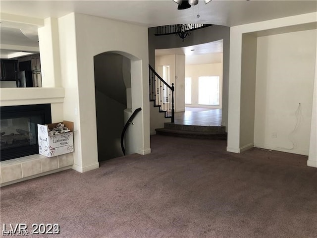 unfurnished living room with dark carpet and a tile fireplace